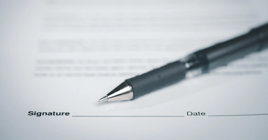 A contract with a pen on top of it.
